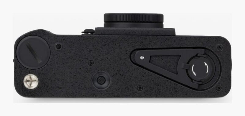 The bottom view of a black camera showing a tripod mount, a battery compartment cover, and a folding film rewind crank.