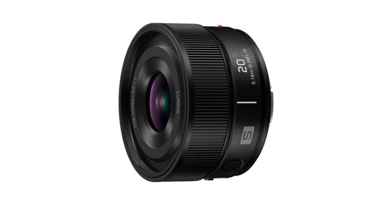 A black Lumix camera lens viewed from the side, featuring a ribbed focus ring and markings indicating a 20mm focal length and 0.18m minimum focus distance.