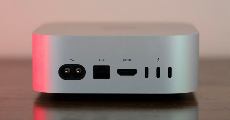 The back panel of a silver computer, showing a power port, an Ethernet port, an HDMI port, and three Thunderbolt ports.