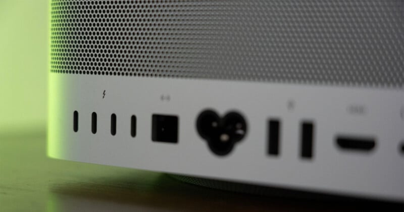 A close-up view of the back panel of a silver computer, showing a row of ports including four USB-C ports, an Ethernet port, a power connector, two USB-A ports, and an HDMI port.