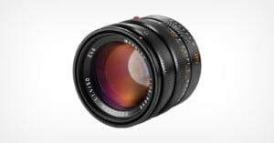 A black manual focus camera lens with a 50mm focal length and f/1.4 aperture, shown at an angle against a white background.