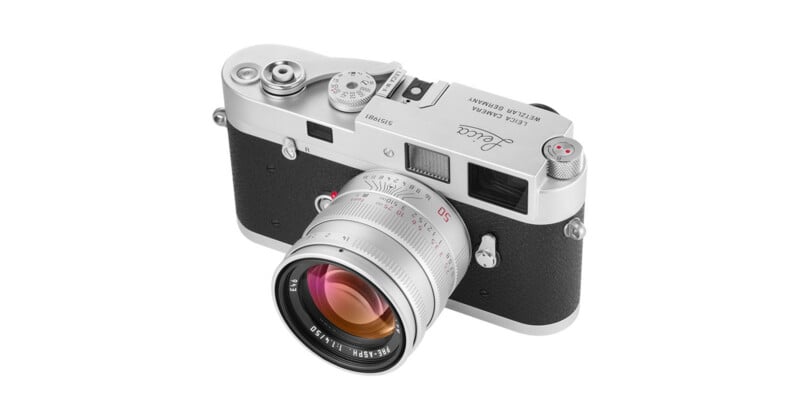 A silver Leica M-A film camera with a 50mm f/1.4 lens attached, viewed from a high angle against a white background.