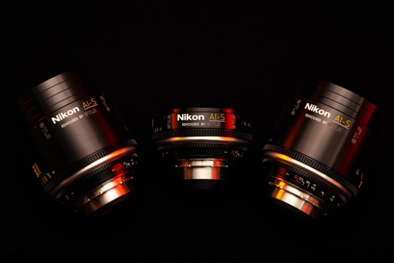 Three Nikon AI-S lenses rehoused by TLS are arranged against a black background with red and orange lighting accents.