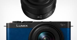 A blue Lumix camera body is shown below a close-up view of its black lens, which features an AF/MF focus switch.