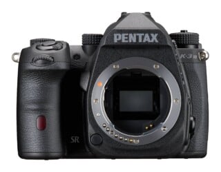 A front view of a black Pentax K-3 Mark III DSLR camera body with the lens removed, showing the sensor and lens mount.