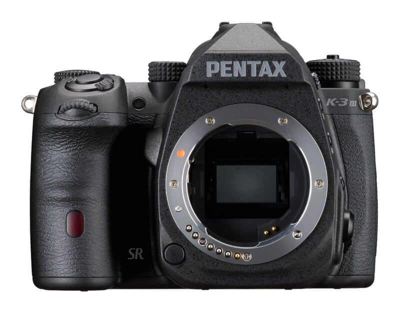 A front view of a black Pentax K-3 Mark III DSLR camera body with the lens removed, showing the sensor and lens mount.