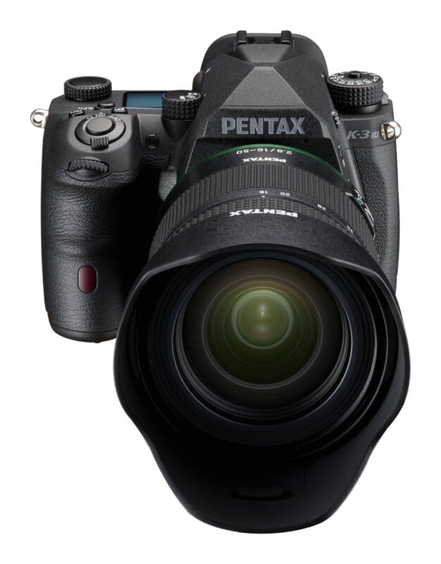 A black Pentax K-3 III DSLR camera with a lens attached, viewed from the front against a white background.