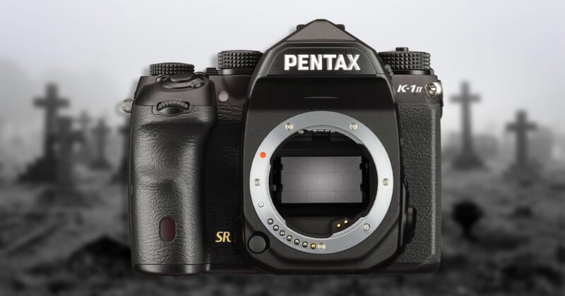 A black Pentax K-1 Mark II DSLR camera body centered against a blurred, grayscale background of a graveyard with crosses.