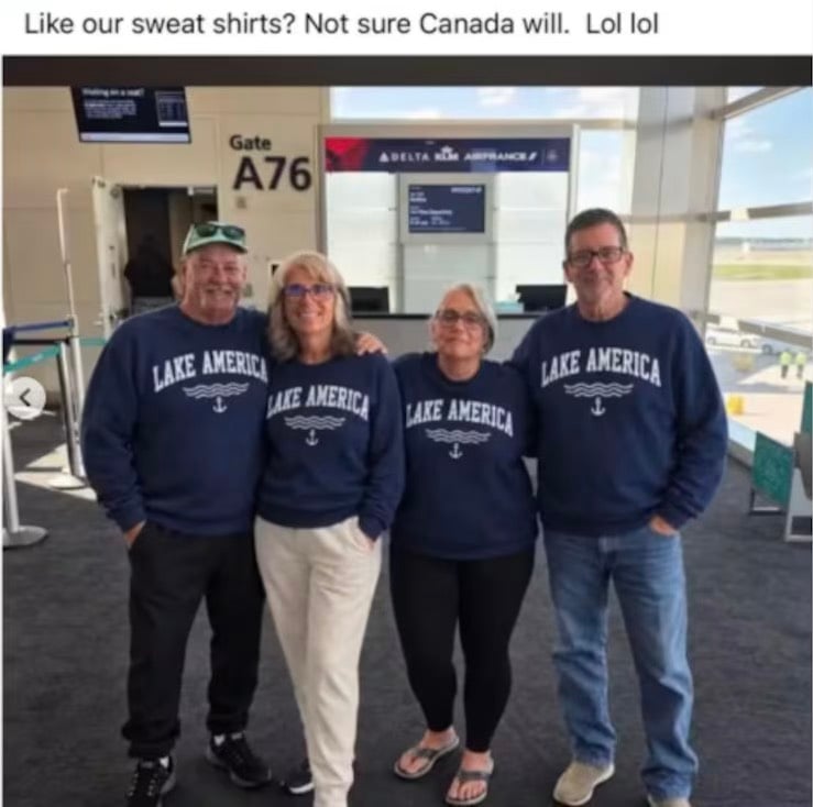 Four people stand in an airport terminal at Gate A76 wearing matching navy blue sweatshirts that say "LAKE AMERICA" with an anchor icon.