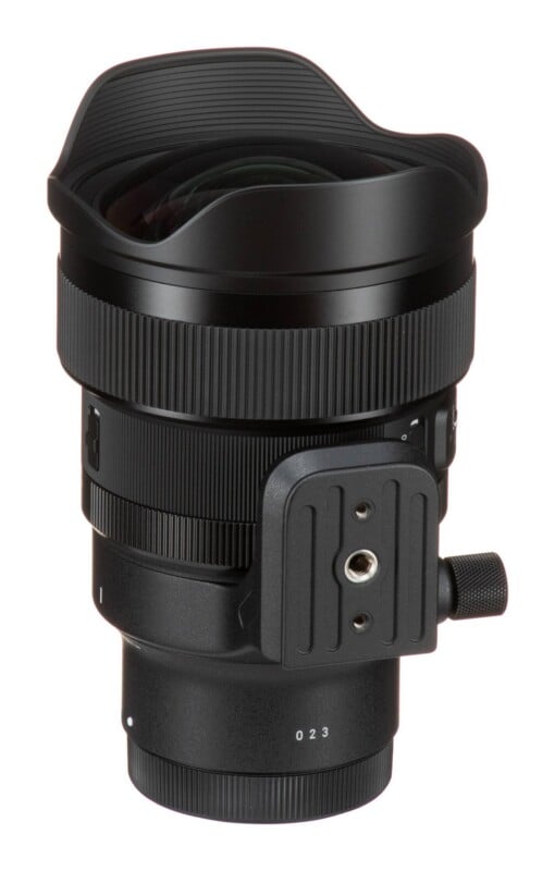A black camera lens with a wide, integrated hood, a textured focus ring, and a side-mounted tripod collar with a metal screw hole.