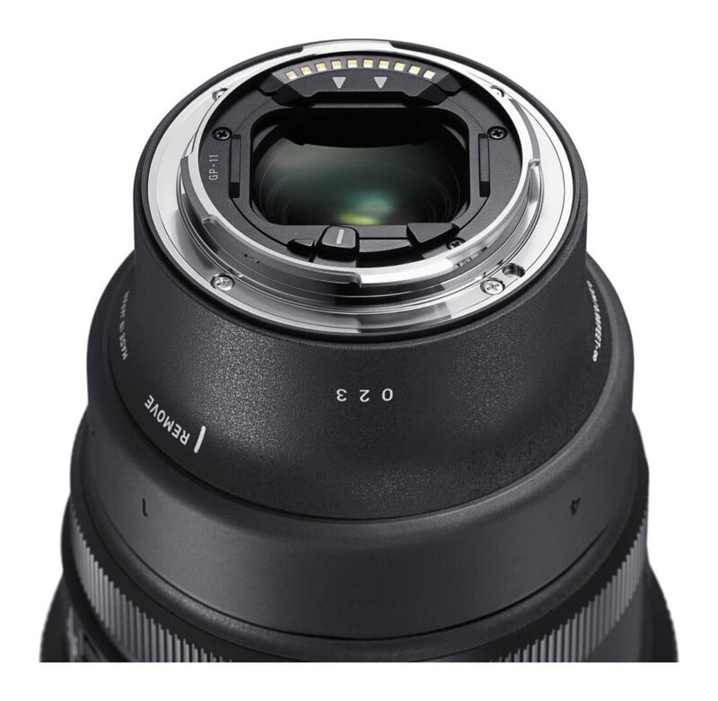 A close-up view of the rear mount of a camera lens, showing the metal bayonet, electronic contact pins, and lens glass.