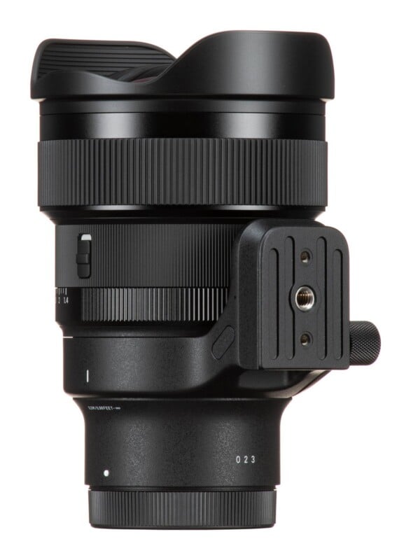 A black camera lens with a built-in tripod mount, featuring a focus ring, a distance scale, and a lens hood, shown against a white background.