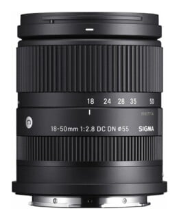 A black Sigma 18-50mm f/2.8 DC DN camera lens with a 55mm filter thread, shown from the side against a white background.