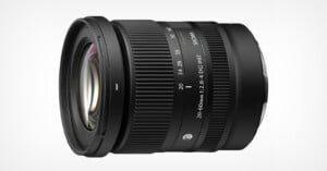 A black Sigma 20-60mm f/2.8-4 DG lens for mirrorless cameras, shown from a side angle against a white background.