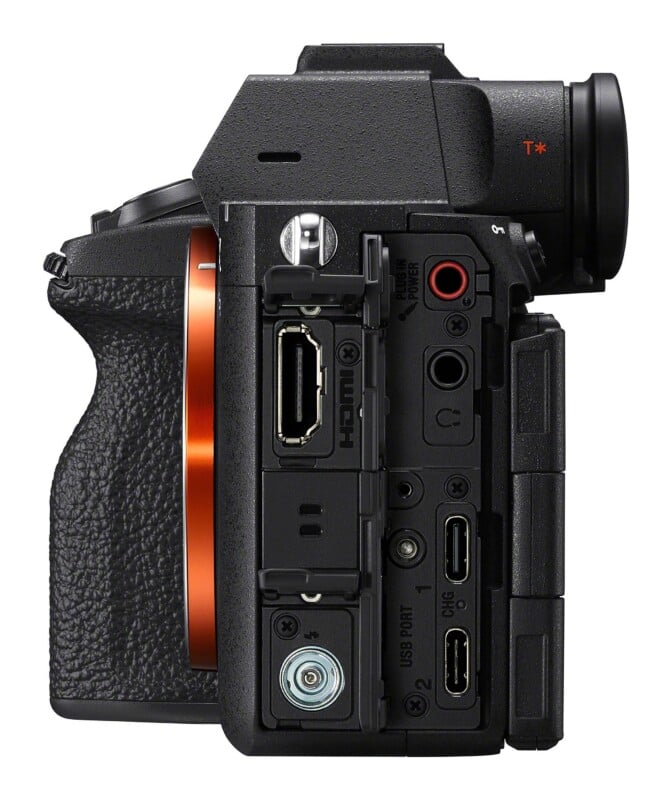 Side view of a digital camera body showing an open port cover revealing an HDMI port, with additional ports for microphone, headphones, and USB connections visible below.