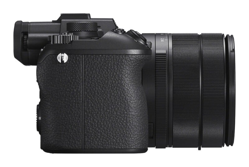 A side view of a black mirrorless digital camera with a lens attached, isolated against a white background.