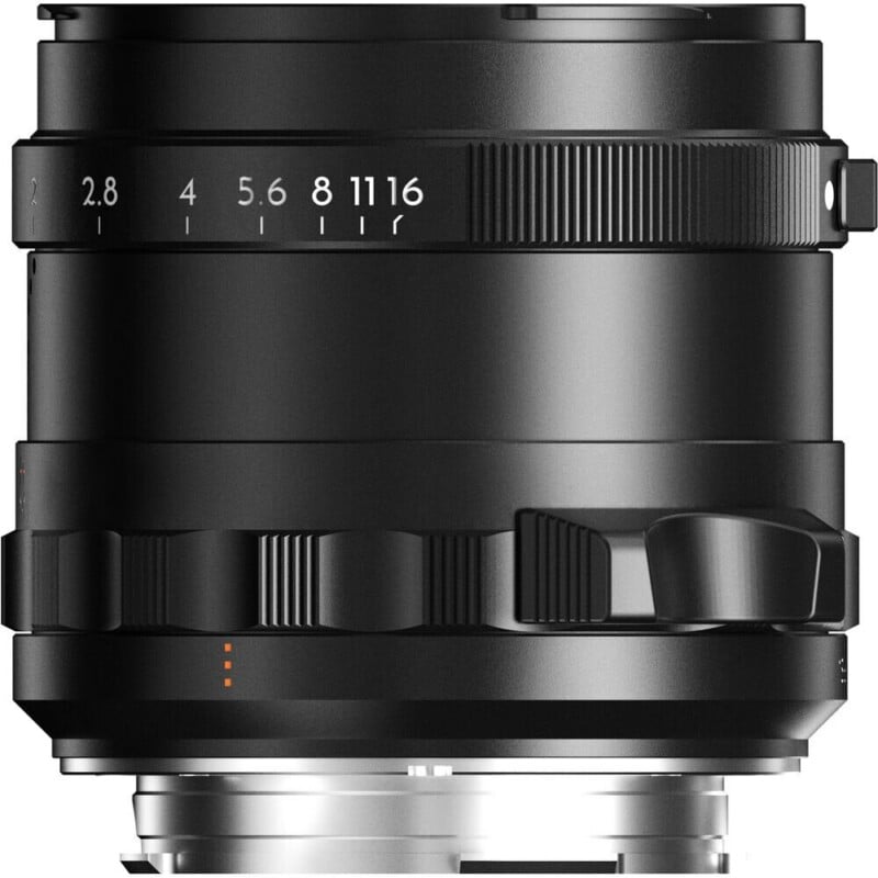 A close-up view of a black camera lens barrel featuring an aperture ring with markings from 2.8 to 16 and a focus tab.