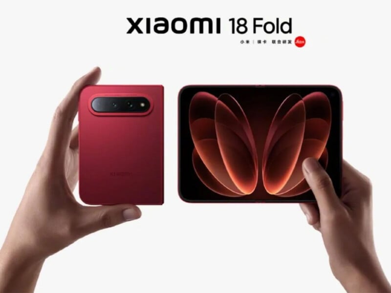 Two hands hold a red foldable smartphone, showing the back casing with a camera module on the left and the open inner screen on the right, with "Xiaomi 18 Fold" text above.