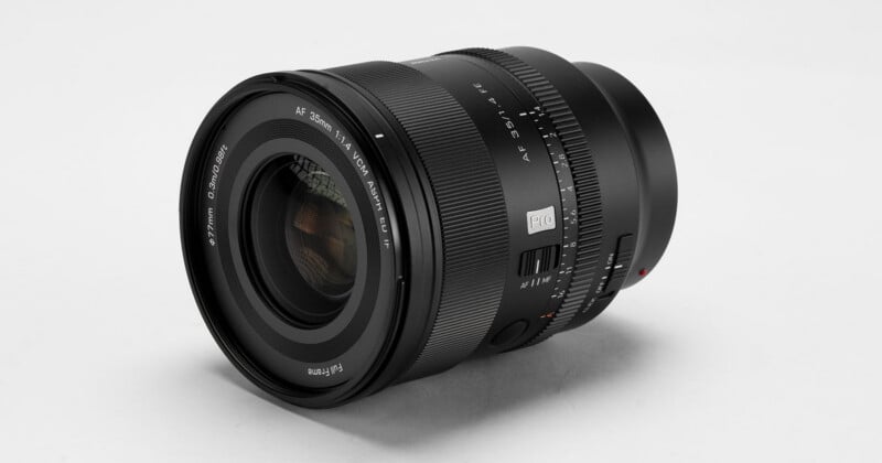 A black camera lens with a 35mm focal length and 1.4 aperture, featuring an aperture ring, focus mode switch, and a 77mm filter thread.