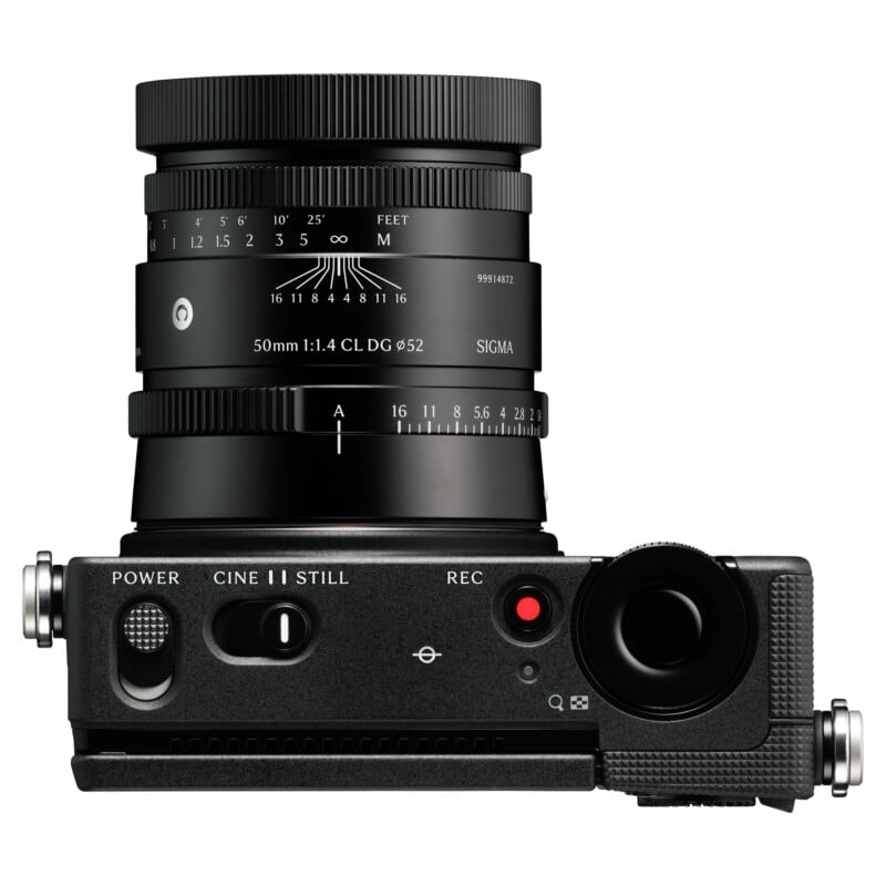 A top-down view of a black digital camera with a Sigma 50mm 1:1.4 lens attached, featuring a mode switch for CINE and STILL.