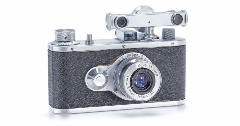 A vintage silver and black film camera with a Leitz Elmar 5cm 1:3.5 lens and a rangefinder accessory mounted on top.