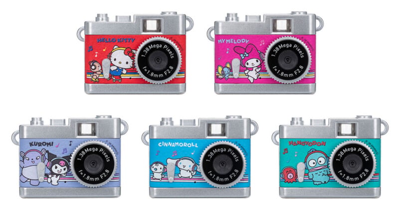 Five small, rectangular digital cameras featuring Sanrio chara cters Hello Kitty, My Melody, Kuromi, Cinnamoroll, and Hangyodon.