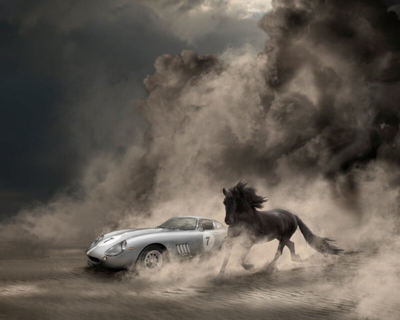 A silver vintage sports car with the number 7 on its side sits in a dusty landscape next to a galloping black horse.