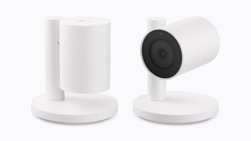 Two white, cylindrical security cameras on circular stands, one facing upward and the other facing forward.