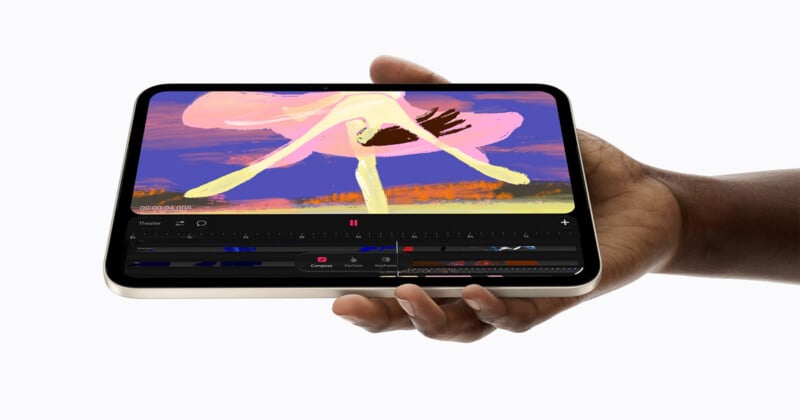 A person's hand holds a tablet displaying a video editing interface with a colorful abstract animation on the screen.