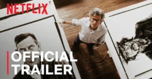 A man with gray hair and glasses stands between two large black-and-white portraits, with Netflix and Official Trailer text overlaid.