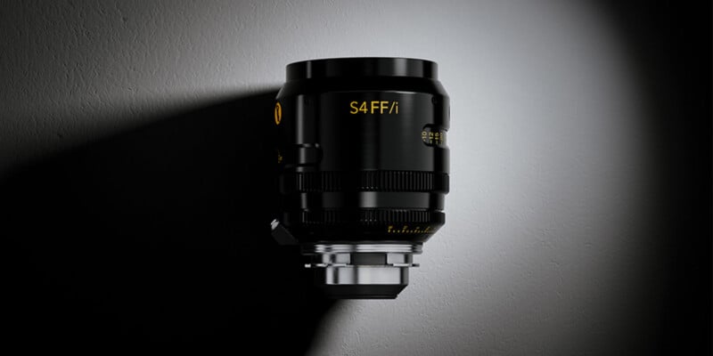 A black Cooke S4 FF/i cinema lens stands vertically against a dark, textured background with a spotlight effect.