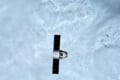 A SpaceX Dragon spacecraft with extended solar arrays floats in space above a dense layer of white clouds.