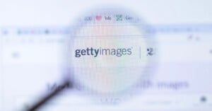 A magnifying glass is positioned over a computer screen displaying the Getty Images logo and website interface.