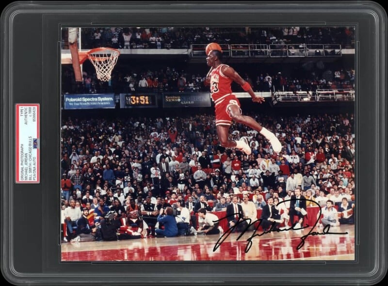 Michael Jordan in a Chicago Bulls uniform mid-air during a slam dunk, signed by the athlete and encased in a PSA/DNA slab.