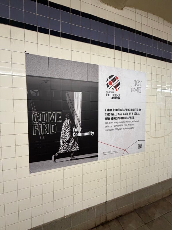 A Fujifilm Fujikina NYC 2026 advertisement on a tiled subway wall features a black-and-white photo of a person in a zebra-print coat walking past the text "COME FIND Your Community.