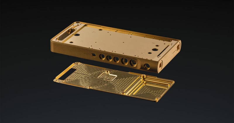 A disassembled gold-colored metal chassis for a portable electronic device, featuring a main housing with circular ports and a matching internal backplate with intricate milled patterns.