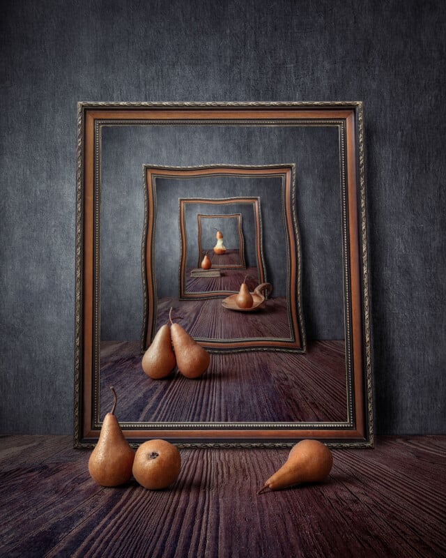 A series of nested picture frames sit on a wooden surface, each containing a reflection of the scene behind it, with several pears arranged in the foreground and within the frames.
