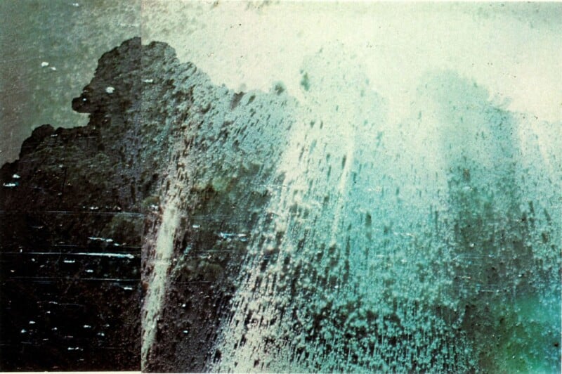A vertical, textured abstract composition features a dark, craggy silhouette on the left transitioning into a bright, light-filled spray of teal and white particles on the right.