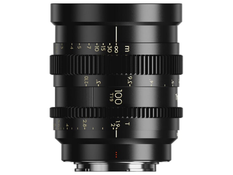 A black cinema lens viewed from the side, featuring focus and aperture rings with white and gold markings, including the text "100 T1.9".