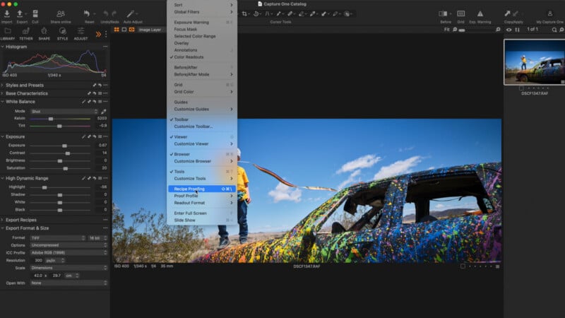 A screenshot of the Capture One software interface showing a photo of a person standing on a colorful, paint-splattered car in a desert landscape, with a drop-down menu open over the center of the screen.