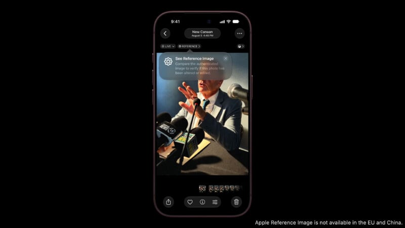 A smartphone screen displays a photo of a man speaking at a press conference with a prompt to see a reference image for authentication.
