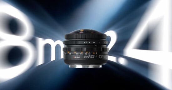 An AstrHori camera lens is centered against a dark blue background with large, blurred white text reading "8mm f2.4" behind it.