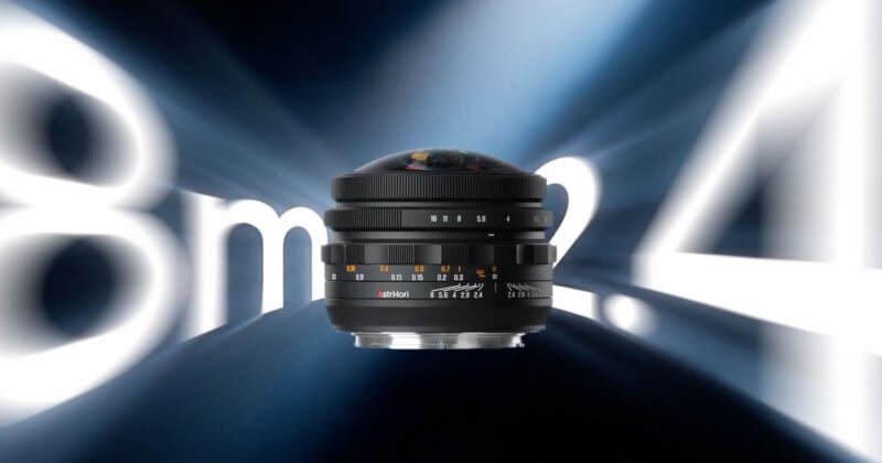 An AstrHori camera lens is centered against a dark blue background with large, blurred white text reading "8mm f2.4" behind it.