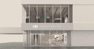 A two-story storefront with floor-to-ceiling glass windows and a sign reading "DJI | HASSELBLAD" above the entrance.