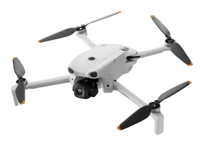 A white quadcopter drone with four black propellers and a front-facing camera gimbal, shown against a plain white background.