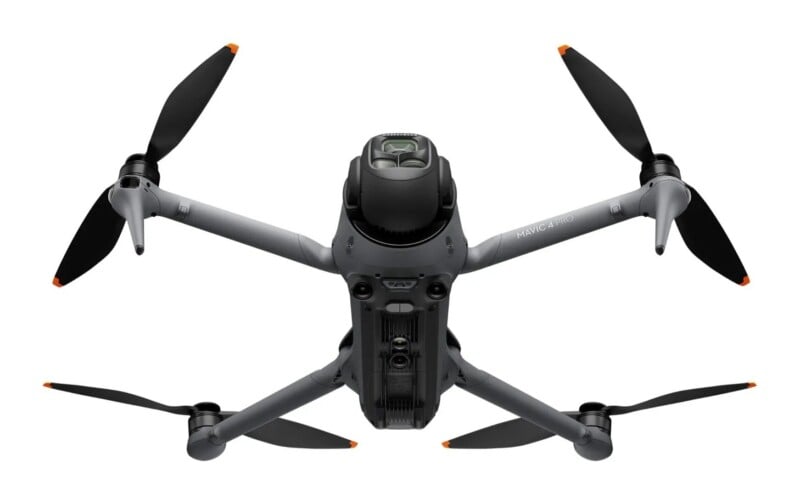 A gray, four-propeller drone viewed from directly below, with the text "MAVIC 4 PRO" printed on one of its arms.