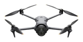 A gray, four-propeller drone is centered against a white background, featuring a front-facing camera module labeled "Hasselblad" and "Mavic 3 Pro" printed on the side arm.