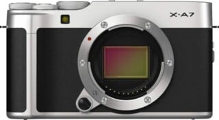 A silver and black Fujifilm X-A7 mirrorless camera body viewed from the front, showing the lens mount and sensor.