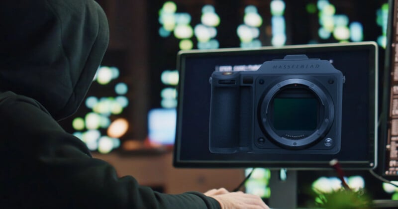 A person in a dark hoodie sits at a computer, with a digital overlay of a Hasselblad camera body displayed on the screen.