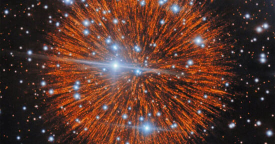 A vibrant, orange-hued nebula radiates outward from a central point, surrounded by numerous bright, blue-tinted stars.